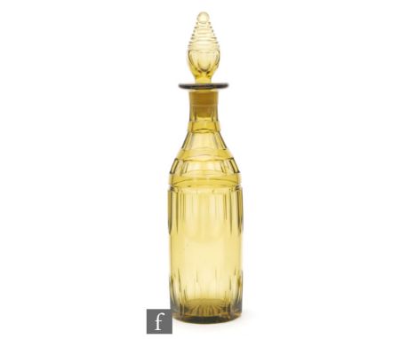 A 19th Century bottle form decanter with slice cut decoration to the deep golden amber ground below a terraced spire form sto