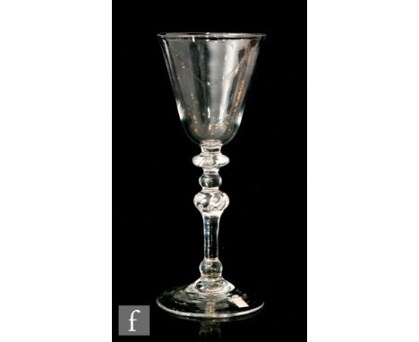 An 18th Century Newcastle light baluster drinking glass circa 1750, round funnel bowl above an upper bladed knop,small knop a