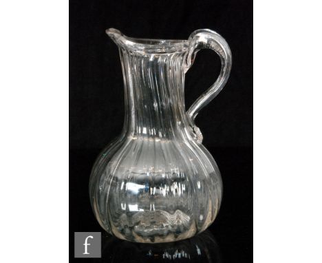 An early to mid 19th Century clear crystal glass jug of globe and shaft form with fine vertical ribbed detail below a folded 