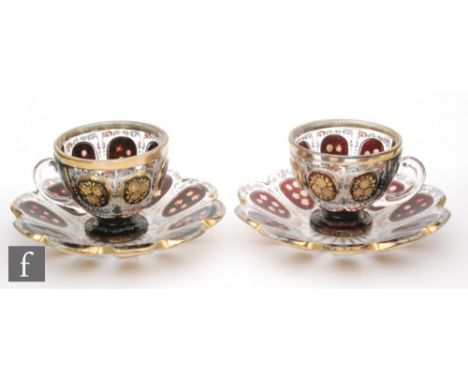 A pair of 19th Century Bohemian crystal cabinet cups and saucers, clear with panels of ruby with gilt and enamelled floral de