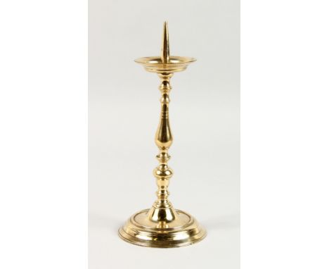 A BRASS PRICKET CANDLESTICK, on a circular base. 11.5ins high.