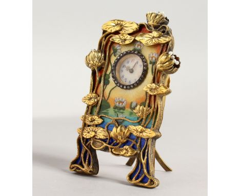 A SUPERB RUSSIAN SILVER, GILT AND ENAMEL CLOCK, in the Art Deco style with lilies and blue enamel, in a Faberge box. 3.5ins h