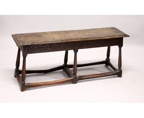 AN 18TH/19TH CENTURY OAK BENCH, with moulded rectangular top, carved frieze on six turned and stretchered legs, with later em