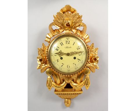 A CARVED GILTWOOD CARTEL WALL CLOCK. 20ins high.