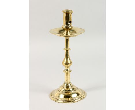 AN 18TH CENTURY CONTINENTAL BRASS CANDLESTICK, on a circular base. 11.5ins high.