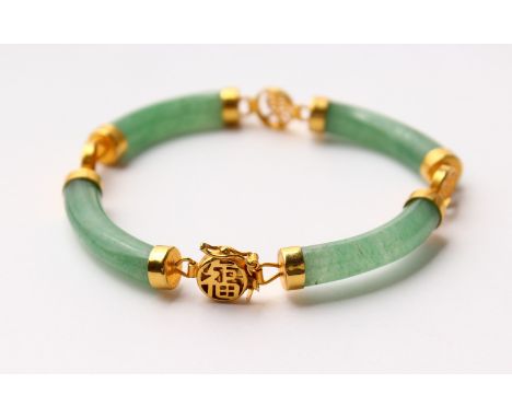 A JADE BRACELET, with four curving sections and gilt metal mounts. 7ins long.