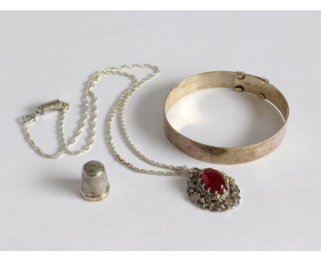 SILVER BANGLE ETC. An engraved silver, adjustable bangle, silver & carnelian pendant & a small sterling silver thimble. Pleas