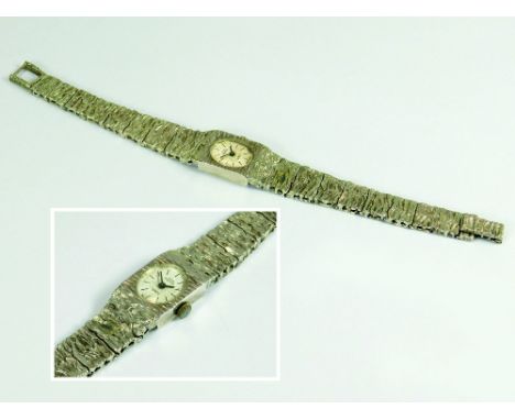 SILVER WRISTWATCH. A lady's mid-1970s, silver cased Swiss Empress wristwatch, on bark textured tapering strap.All watches in 