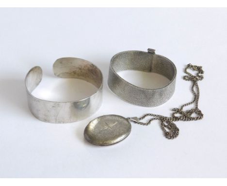 SILVER LOCKET ETC. A mid 1960s silver locket & chain. Also, a plain silver torque bangle & a silver mesh bangle. Please note 