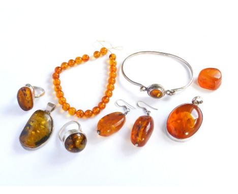 AMBER. Two modern silver mounted amber pendants & two silver mounted amber dress rings. Also, a sterling silver & amber bangl