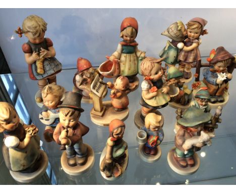 Fifteen Goebel figurines including angel singing, boy on fence, girl with basket, etc.