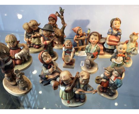 Fourteen Goebel figurines including girl with birds, girl with lamb, girl on tree, etc.