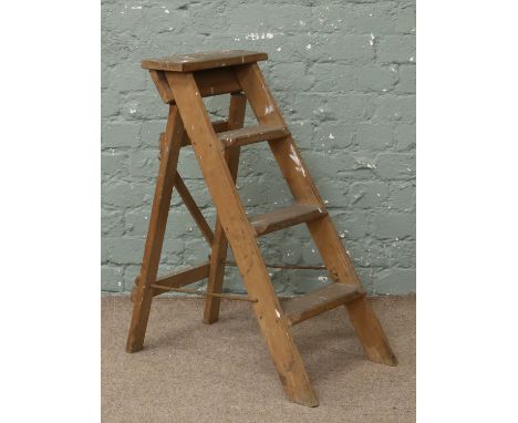 A set of vintage wooden step ladders.