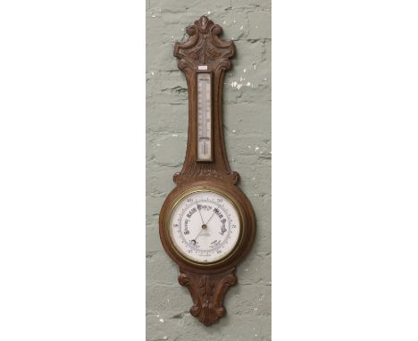 A carved oak wall barometer.