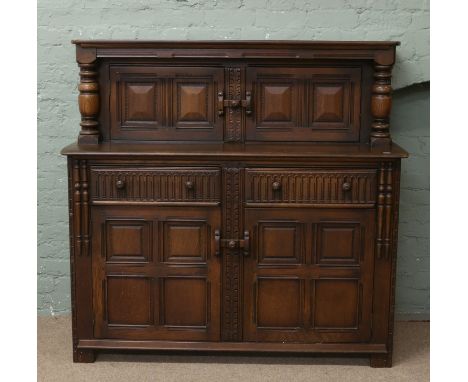 An Ercol oak court cupboard.