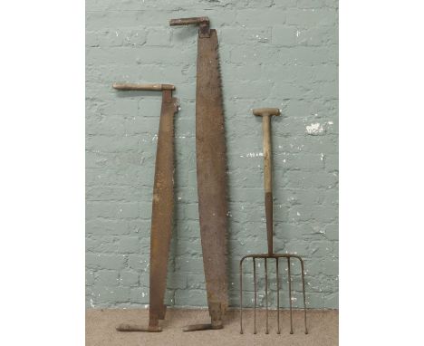 Two cross cut saws and a potato fork.