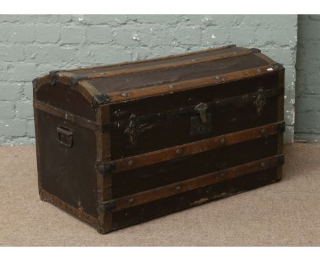 A vintage dome top wood bound travel trunk.