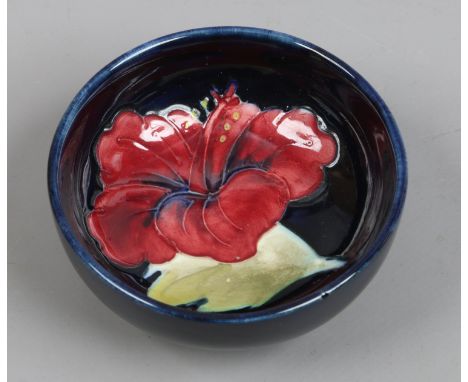 A Moorcroft trinket bowl decorated in the hibiscus pattern.