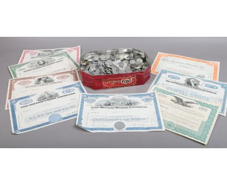 A tin of old foreign coins and share certificates.