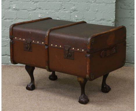 A steamer trunk converted into a coffee table with ball and claw feet.