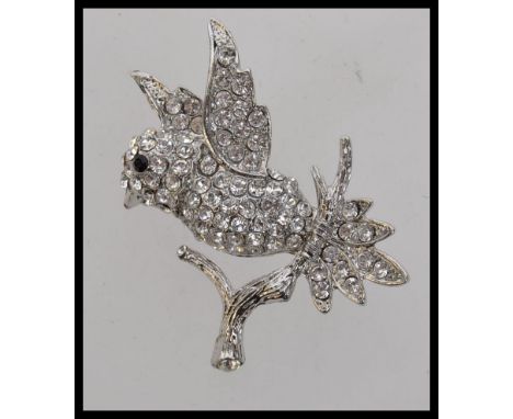 A vintage pave set diamonte bird brooch perched on a branch. Measures 5cms.