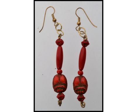A vintage pair of red coral scarab beetle Egyptian revival earnings in the style of Neiger