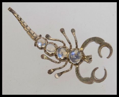 A vintage white metal and moonstone scorpion brooch.