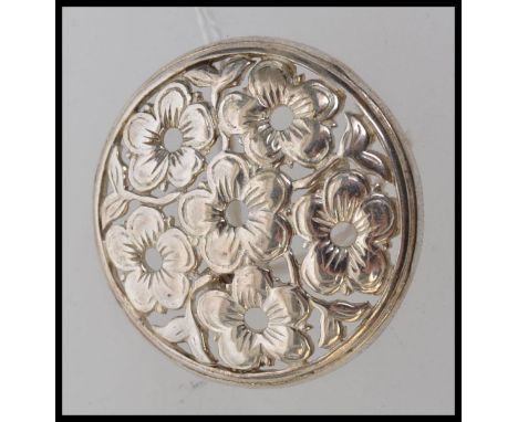 A vintage 925 silver brooch with pierced flower decoration. Measures 3.5cms diameter. Weight 8.7g.