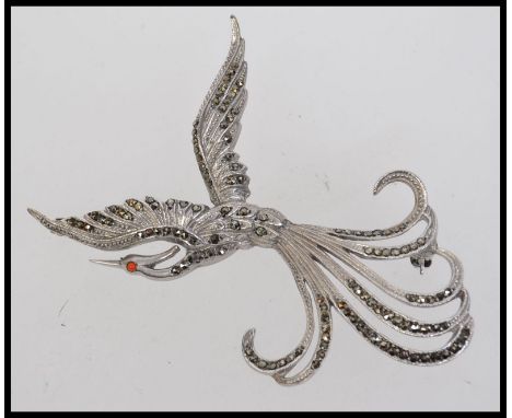 A large vintage silver and marcasite brooch in the form of a elaborate bird of paradise with an orange stone eye. Marked silv