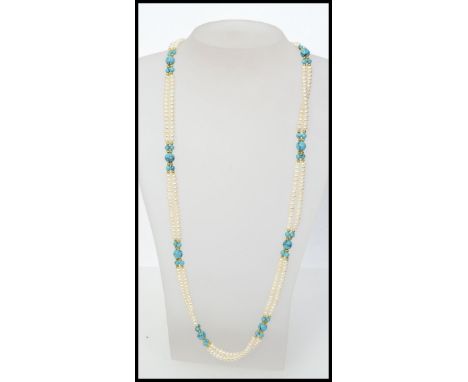 A Danbury Mint twin strand cultured button pearl and turquoise bead necklace with gold plated stylized clip clasp with origin