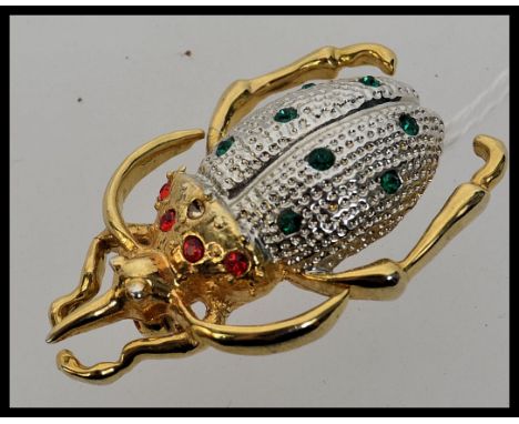 A large vintage scarab beetle brooch set with green and red rhinestones.  Weight 15.4g. Length 5cm approx.