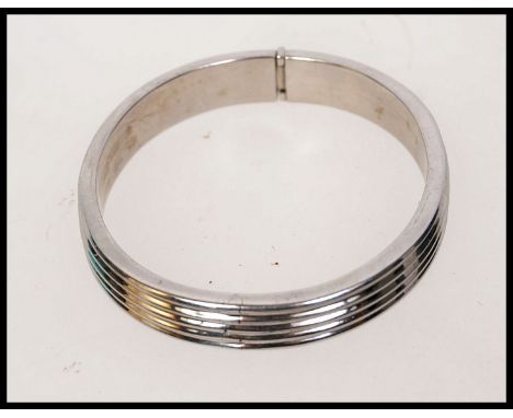 An Art Deco style 925 silver hallmarked bangle bracelet with hidden clip clasp. Weight 19g.