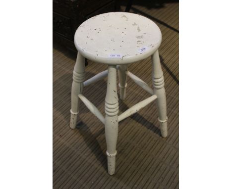 A white painted wooden circular topped four-legged stool 