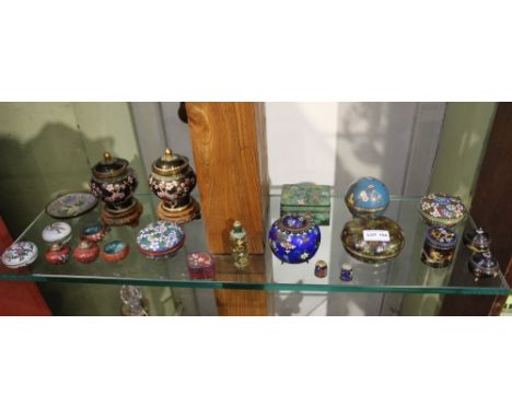 A shelf full of small -sized Oriental cloisonné decorative items 