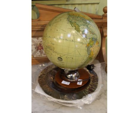 An illuminating table globe of German manufacturer, together with a series of polished metal under plates 