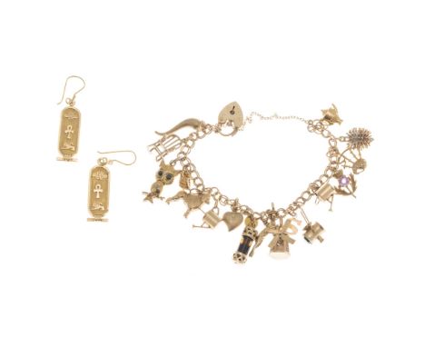 A 9ct gold charm braceletcomposed of double curb links with padlock clasp, suspending various charms including a teapot, bagp