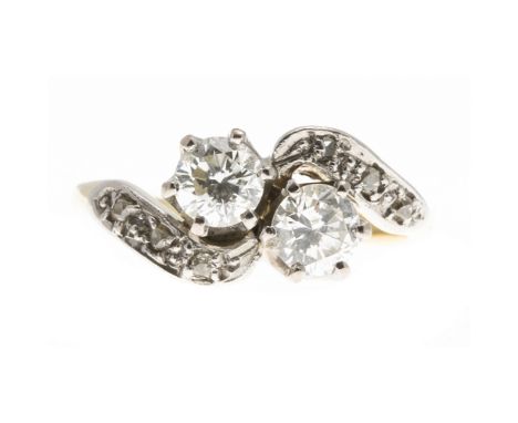 A two stone diamond ringclaw set with two round brilliant cut diamonds, the scrolling shoulders set with rose cut diamonds, t