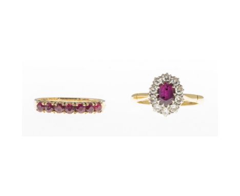 Two ruby ringsthe first claw set with an oval cut ruby in a border of round brilliant cut diamonds, to a plain 18ct gold shan