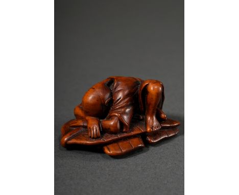 Helles kompaktes Buchsbaum Netsuke "Auf Bananenblatt schlafender Bauer", verschieden große Himotoshi, um 1850, L. 4,6cm, Vgl.