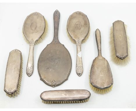 A group of six 20th Century silver mounted engine turned brushes and a dressing table mirror, hallmarked, various dates and m