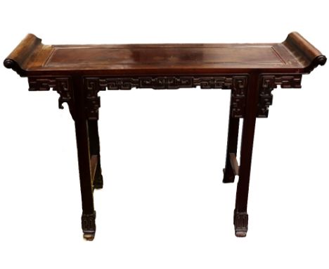 A 20th century Chinese rosewood altar table of typical form, with carved scroll ends and Greek Key blind fretwork decoration,