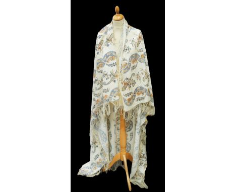 A cream beaded shawl in a colourway of scrolls and foliage in blues and greens, fringing around the hemline, probably around 