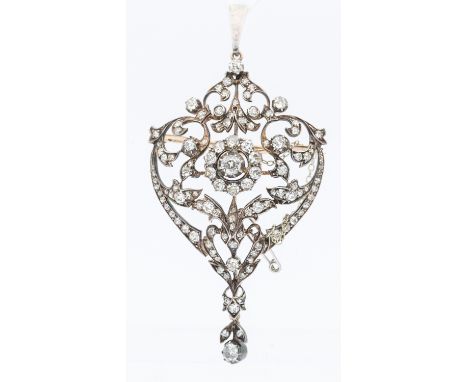 An Edwardian diamond set pendant brooch, comprising an open work scroll and foliate design grain set with diamonds, the centr