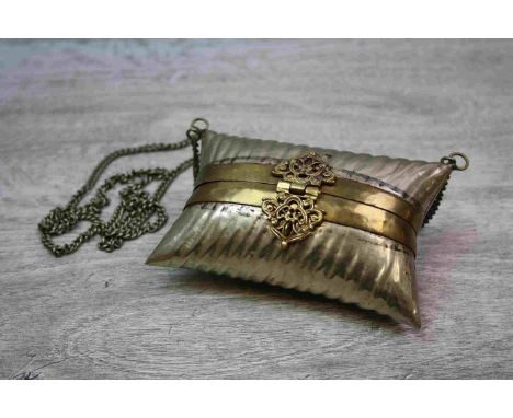 Small metal handbag in the form of a cushion, centre hinge opening to reveal velvet lined interior, the clasp and hinge with 