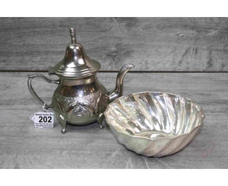 White metal teapot raised on four feet, the lower half with naive decoration, height approximately 17cm together with a white