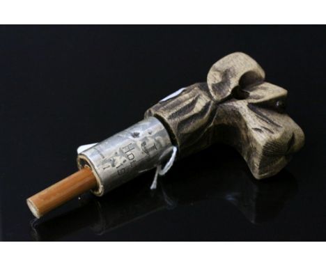 A carved dog head walking stick handle with silver collar