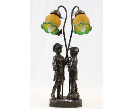 Table lamp modelled as a boy and a girl in school uniform, resin, the glass shades in yellow and green bell shaped glass, hei