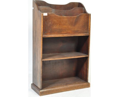 A 20th century circa 1940s oak book trough having a set of wooden dividers to the top over three shelves raised on a plinth b