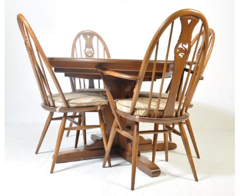 A 20th century Ercol beech and elm wood dining room suite. The suite in the Swan pattern having an extending circular table t