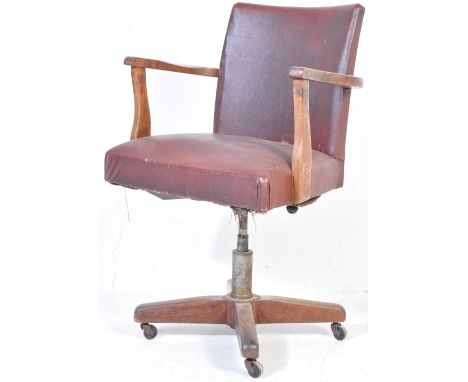 An early 20th Century retro vintage industrial swivel desk chair in the manner of Hillcrest. Brown leatherette upholstered ba